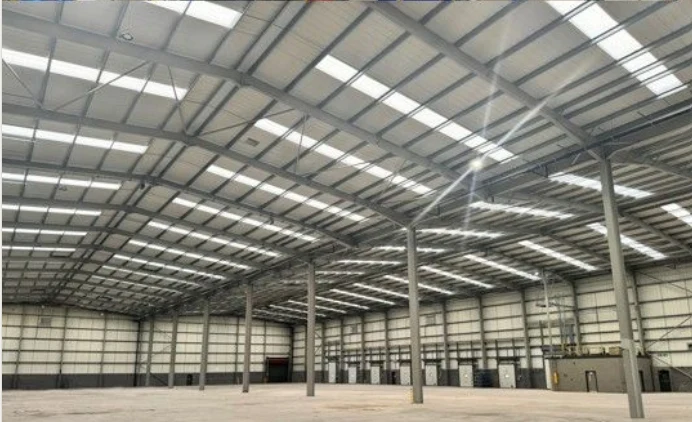 The same Fradley industrial hall cleared to an empty floor with exposed steelwork and rooflights