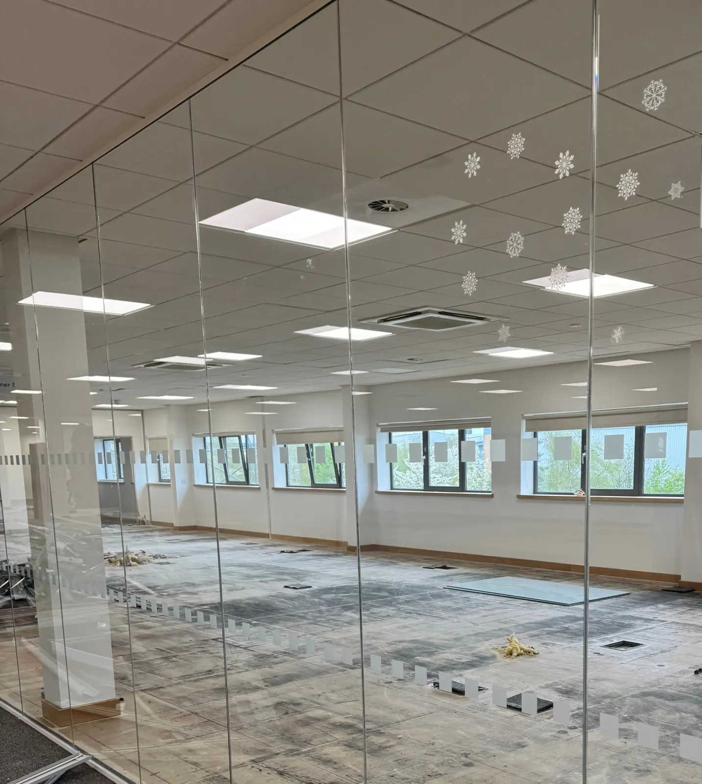Office area at Fradley behind glazed partitioning, with flooring lifted and protection down